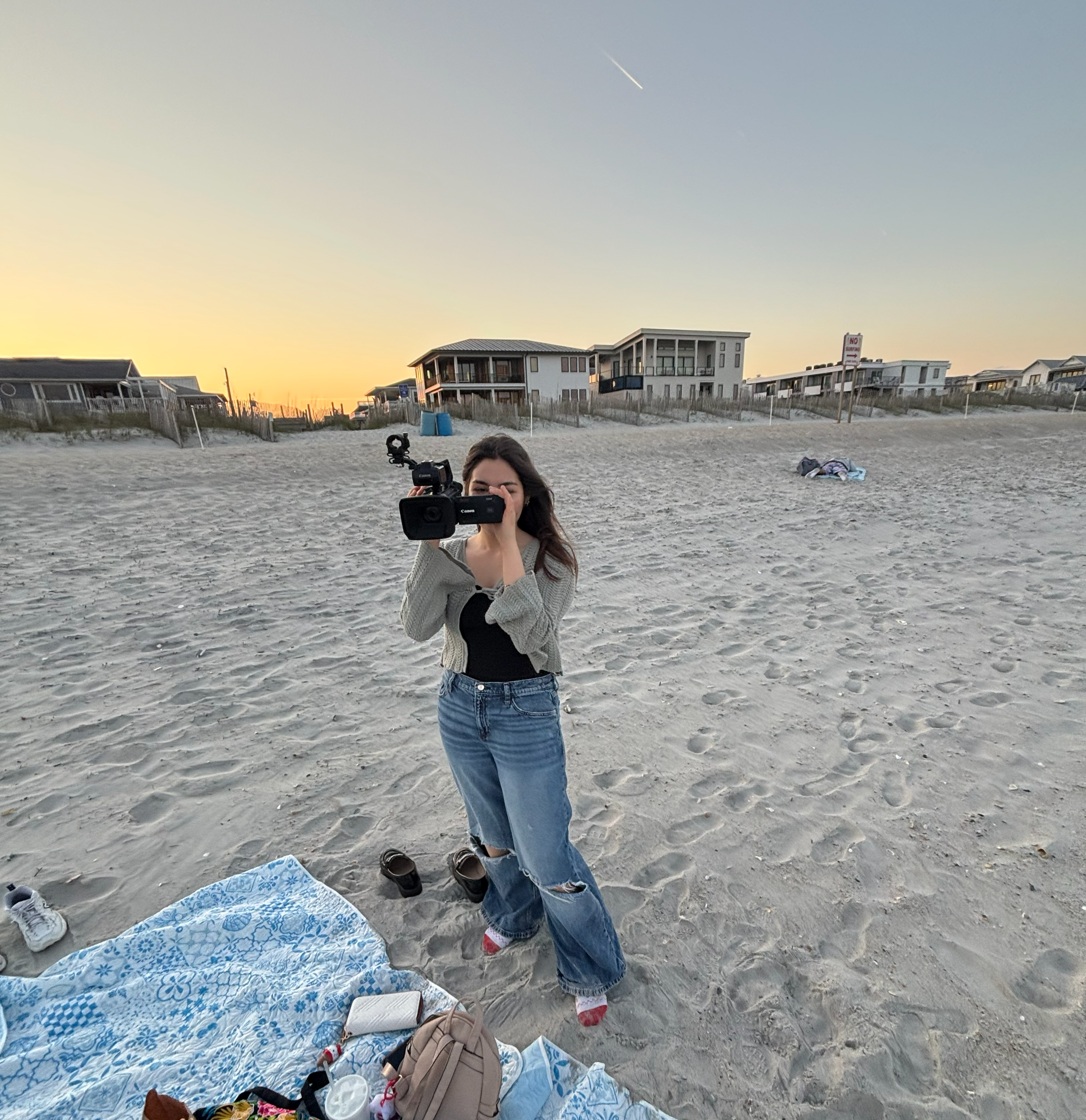picture of me wearing a green shaw and blue jeans while looking down at the camera I am holding.